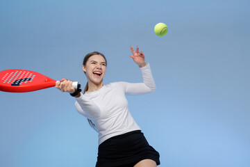 Fototapeta premium Excited Female Player Practicing Padel Tennis with a Red Racket