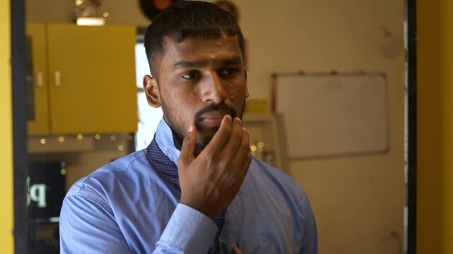 Young Indian male in office college attire adjusts tie while staring into a mirror, unhappy with acne-ridden tanned skin; an intimate bedroom moment reflecting self-image concerns and insecurity
