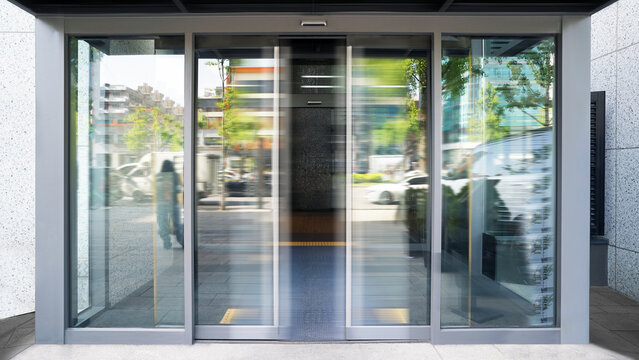 Automatic Sliding Glass Door Entrance of Modern Building with Motion Blur in Urban City