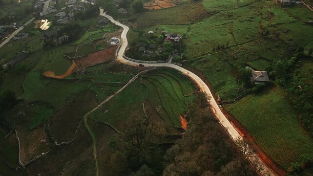 Sapa, L&agrave;o Cai Province, Vietnam - A Winding Road Snakes Through Lush Terraced Fields and Scattered Hillside Homes - Aerial Drone Shot