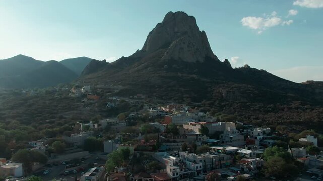 Pe&ntilde;a de Bernal backward aerial reveals Bernal pueblo magico city center and Saint Sebastian's Temple