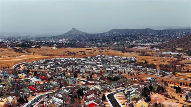 Small neighborhood town of Castle Rock landmark Colorado aerial drone south Denver Front Range snow covered mesa cars home buildings snowy cold morning snowing cloudy open space forward motion