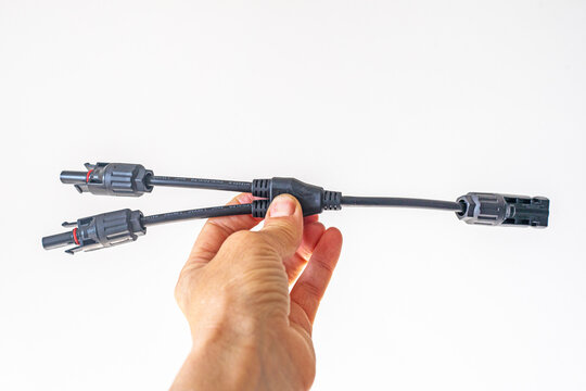 Holding a close-up of 2Y/3Y/4Y solar connectors for parallel connection, 30A, 1000V, photovoltaic sockets for solar panel cables, 2 pcs on the table