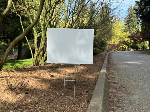 Yard sign mockup wuth shade near the walking path in the park. Blank yard sign in green grass on sunny day