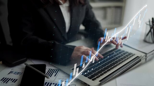 A business professional engaged in data analysis on a laptop surrounded by charts and graphs, representing technology-driven productivity in the modern workplace. Copula
