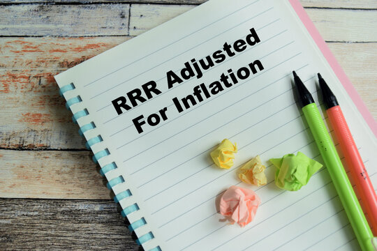 Concept of RRR adjusted for inflation write on book isolated on Wooden Table