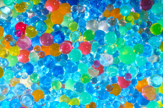 Colorful transparent water beads background with vibrant gel spheres texture