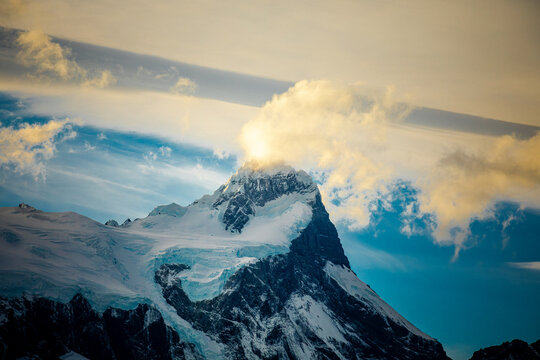 Snow covered mountain peak with glowing cloud cap, Patagonia Chile