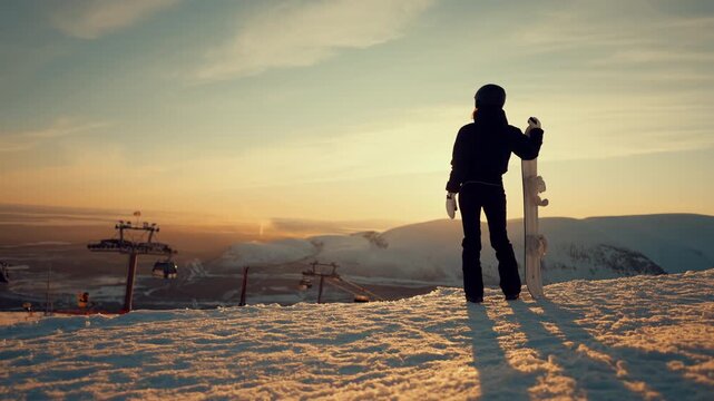 Be at top, conquer summit and get goal, woman snowboarder admiring mountains. Back view of sportswoman with snowboard standing on peak of mount and watching picturesque landscape with ski resort