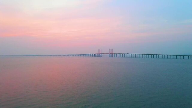 Oresund Bridge over calm sea at pastel sunset