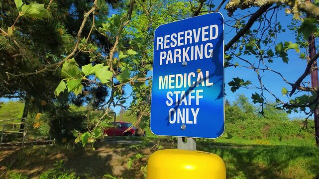 Reserved parking sign for medical staff with greenery in the background
