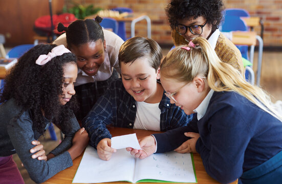 Students, reading and children with note in classroom, learning and smile with secret or information. Education, learner and kids with paper in elementary school, happy and friends with letter
