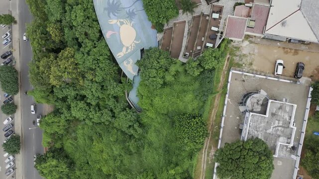 Drone flies south in bird's eye view of Parque dos Namorados on an overcast day in Maputo, Mozambique