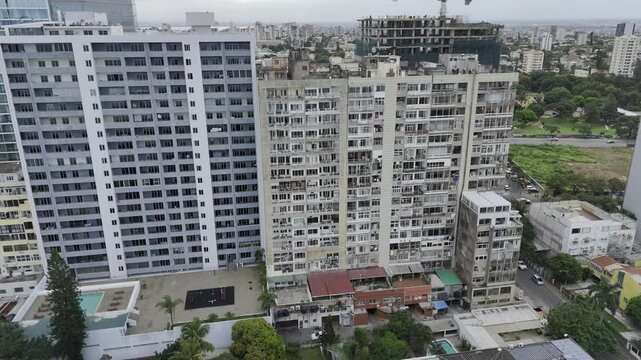 Drone lowers from view of high rise apartments, down to the Caracol on an overcast day in Maputo, Mozambique