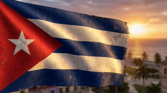 cuban flag waving at sunset over tropical coast city