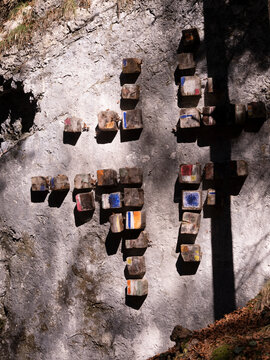 Outdoor art installation featuring colorful painted wooden blocks on a rugged rock face, a unique tourism destination at Respiro degli alberi path, Lavarone, Paganella, Trentino, Italy.