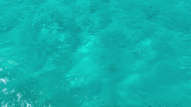 background with blue ripples and waves on the water surface. Waves reflecting light, a swimming pool, sea, ocean. Clear water, splashes, waves, viewed from above. Summer vacation, relaxation, weekend