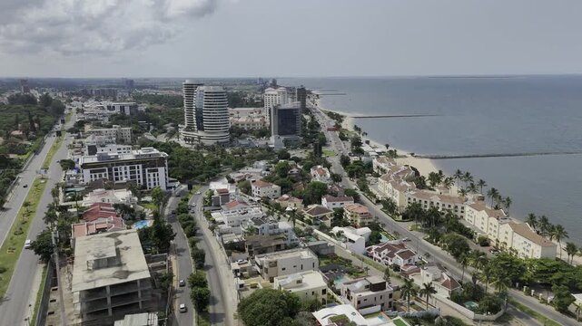 Drone lowers in view of Sommerschield on the beach on an overcast day in Maputo, Mozambique