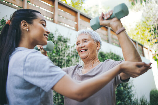 Physiotherapy, weights and senior woman outdoor for healing, muscle strength and consulting. Happy, physical therapist and elderly patient with dumbbell for arthritis, mobility exercise and support