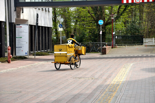 Deutsche Post, Kurierfahrer liefert Post mit dem Fahrrad in der Stadt aus