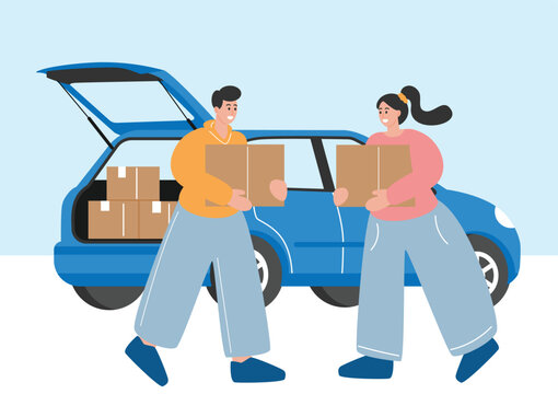 Happy couple loading cardboard moving boxes into a car trunk