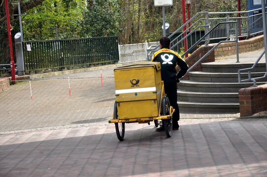Deutsche Post, Kurierfahrer liefert Post mit dem Fahrrad in der Stadt aus