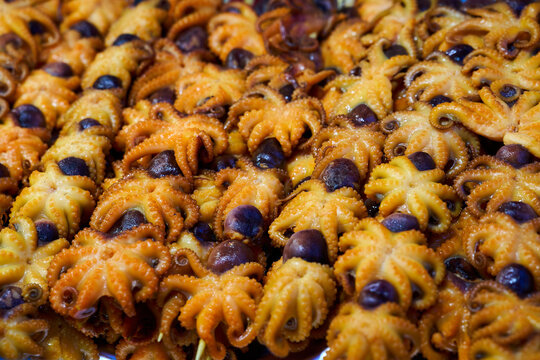 Spicy grilled baby octopus skewers (Jukkumi) on display at a traditional Korean street food market stall.