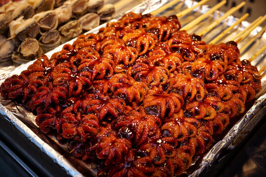 Spicy grilled baby octopus skewers (Jukkumi) on display at a traditional Korean street food market stall