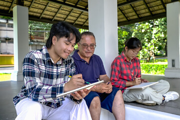 Fototapeta premium American architect teacher teaching young Asian architect collage students creating and drawing in outdoor class
