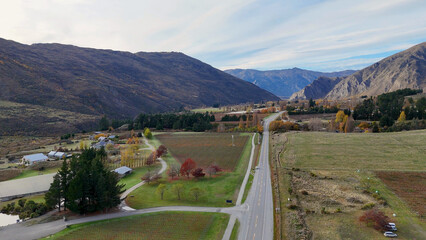 Naklejka premium Aerial View of a Scenic Road Through Queenstown Vineyards and Mountains