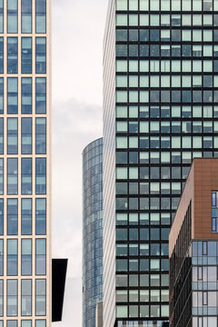 Urban architecture view of frankfurt skyline featuring modern glass towers around a financial office skyscraper under pale overcast sky