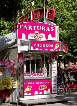 Pink food stall selling farturas, churros, and sweets outdoors