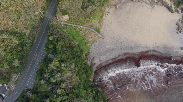 Aerial backward drone shot from Toji Sand Ski Slope to Ryugu Sea Cave, top down coastal landscape in Minami Izu Japan