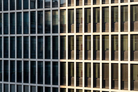 Corporate background built from architecture repetition in a modern urban office building facade where grid pattern and windows create rhythm