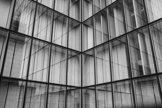 Corporate abstract mood built from monochrome glass facade where modern lines and pattern wrap the building architecture in silence