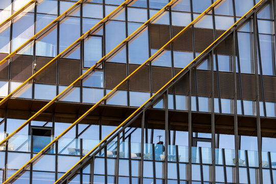 Reflections cut a diagonal path through modern glass facade where pattern defines the building architecture for an abstract corporate scene