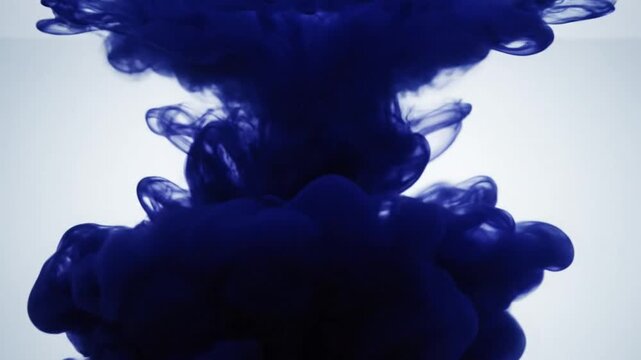 Dark blue liquid expanding in clear water