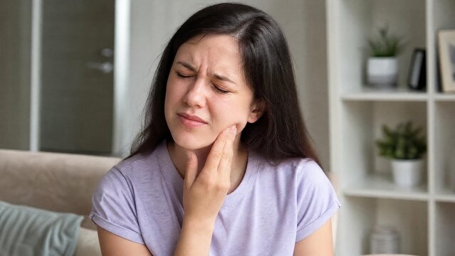 Young Woman Suffering from Severe Toothache or Dental Pain at Home