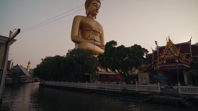 Large golden Buddha statue at Wat Paknam Phasi Charoen in Bangkok Thailand during daylight. Iconic Buddhist landmark with traditional temple architecture and spiritual atmosphere.