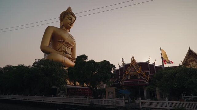 Large golden Buddha statue at Wat Paknam Phasi Charoen in Bangkok Thailand during daylight. Iconic Buddhist landmark with traditional temple architecture and spiritual atmosphere.