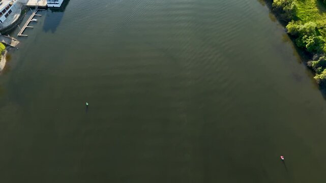 Aerial view of two small boats floating on the calm dark green water of the Douro river in Distrito da Guarda, Portugal.