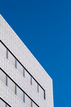 White concrete building facade forms diagonal line under deep sky with copy space minimal urban exterior architecture modern texture for brochures