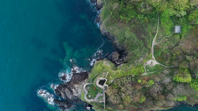 Aerial view of the historic St Catherine's Castle ruins on the rocky cliffs overlooking the turquoise waters of Fowey Harbour in Fowey, England, United Kingdom.