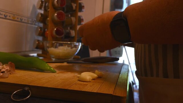 Close up of woman hands peeling garlic on a wooden board