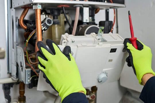 Technician repairing the boiler  at home.