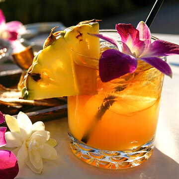Tropical pineapple cocktail with orchid flower garnish