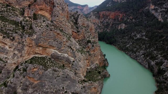 Spectacular 4K drone flight over the turquoise J&uacute;car River in Spain, navigating through a deep canyon with massive cliffs and lush forest slopes.