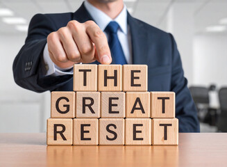Naklejka premium The great reset - Geschäftsmann zeigt auf den Text 