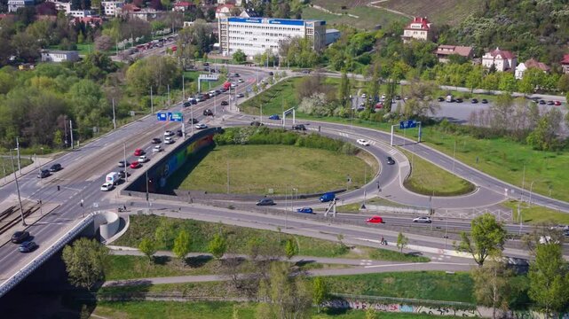 Aerial view of heavy traffic on a complex highway interchange in the Prague-Troja district with city infrastructure and residential buildings in daylight