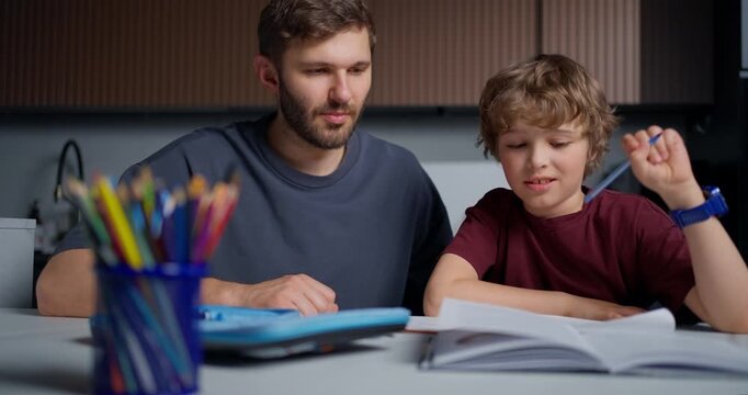 Father Guides Reading. Child Learning With Gentle Encouragement. Father And Son Share Quiet Learning Moment